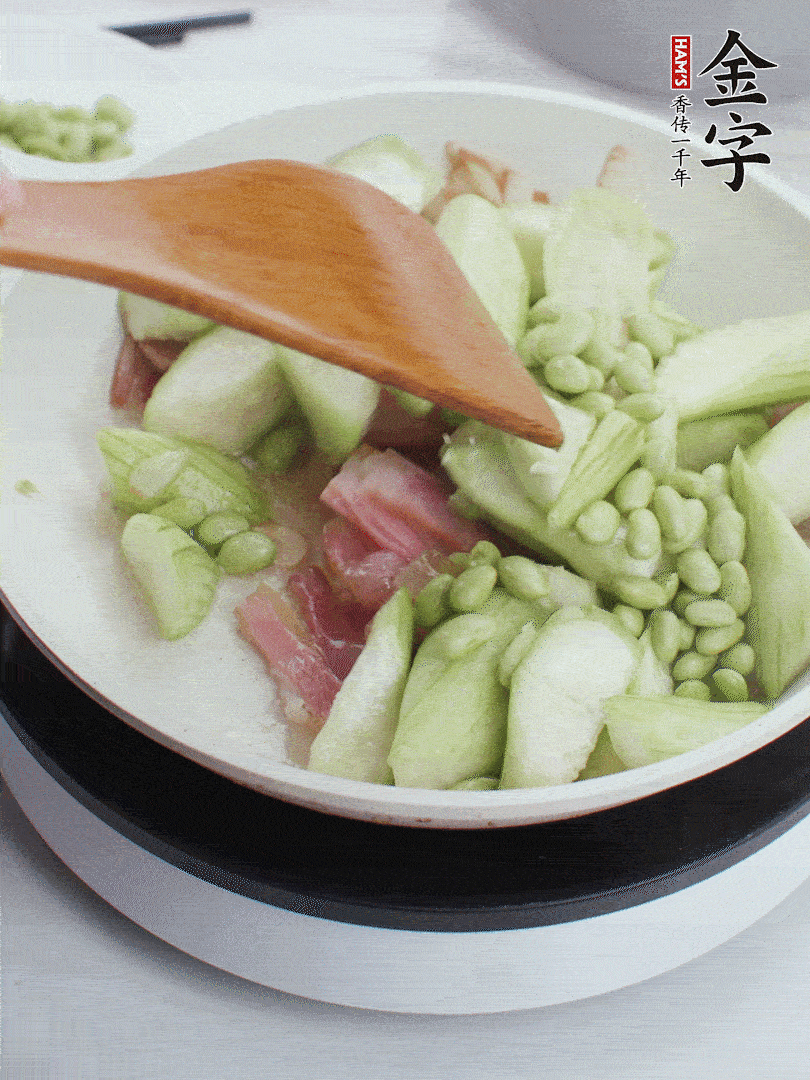 依次下絲瓜、青豆翻炒，炒至絲瓜打蔫縮小。