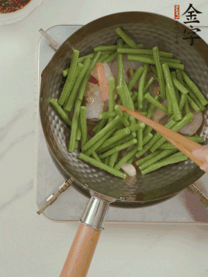 下掰好的缸豆段翻炒，略燜煮。