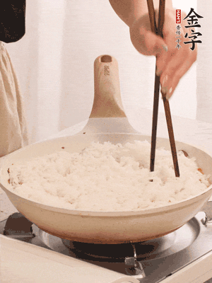 把瀝干水分的米飯均勻鋪在上面，筷子戳幾個(gè)洞，以便透氣，轉(zhuǎn)小火蓋上蓋子燜至水分收干，大概10分鐘。